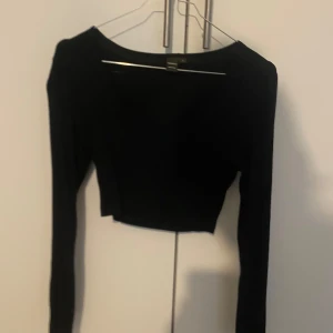 Svart croppad topp från SheinSXY - Säljer en svart croppad topp från SheinSXY. Den är långärmad och perfekt för en stilren look. Toppen är i bra skick och passar både till vardags och fest.