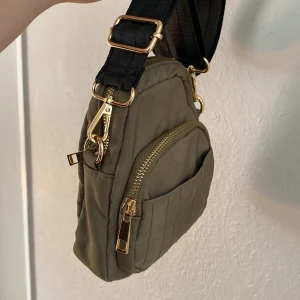 Väska - Liten militärgrön väska i vattenavstötande material💚