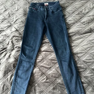 Blå skinny jeans från Tommy Hilfiger - Super stretchiga skinny jeans från Tommy Hilfiger med hög midja. Klassisk femficksdesign med dragkedja och knapp framtill. Mycket fint skick.