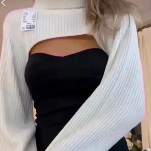 Vit ribbad polotopp - Säljer en superfin vit ribbad polotopp med en unik design. Den har en öppen del vid bröstet som ger en cool look. Perfekt för att styla med olika outfits!