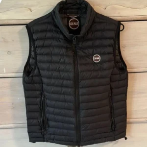 Svart dunväst från Colmar - Snygg svart dunväst från Colmar med dragkedja framtill och två praktiska fickor med dragkedjor. Perfekt för lager-på-lager under kyliga dagar. Märkeslogga på bröstet ger en stilren touch.