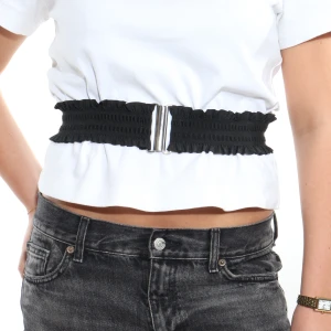 Svart elastiskt bälte med silverdetalj - Snyggt svart elastiskt bälte med en stilren silverdetalj framtill. Perfekt för att ge en extra touch till din outfit. Passar bra till både jeans och klänningar.