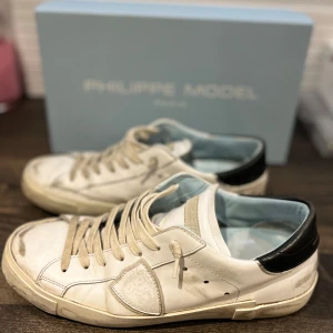 Vita sneakers från Philippe Model - Säljer nu ett par stilrena Philippe Model. Skorna är i fint skick förutom ett litet slitage på höger sula.