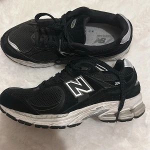 Svarta New Balance sneakers - Snygga svarta New Balance sneakers med silverdetaljer och snörning. Perfekta för en sportig look med bekväm passform och slitstark sula. Storlek 37,5, har använts sparsamt😊pris kan diskuteras❤️
