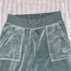 Gröna velourbyxor från Juicy Couture - Snygga gröna velourbyxor från Juicy Couture med elastisk midja och snörning. Jätte snygga, älskar dem men tvyärr passar dem inte längre. Storlek xss men passar även som xs