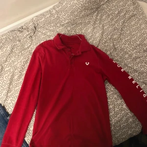 Röd pikétröja från True Religion - Säljer en röd true religion longsleeve som är storlek s men passar nog bättre på Medium