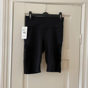 Svarta cykelshorts från Stronger - Snygga svarta cykelshorts från Stronger med meshdetaljer på sidorna. Taggen sitter kvar, så de är helt nya och redo för användning. 🖤