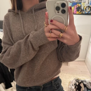Beige stickad hoodie - Mysig beige stickad hoodie med luva och långa ärmar. Perfekt för kyliga dagar. Den har en bekväm passform och ribbade muddar vid ärmslut och nederkant. Kommer ej till användning längre därav säljer jag den.  Den har blivit lite nopprig men inte så himla synligt, skriv för bilder isåfall🥰🥰🥰 