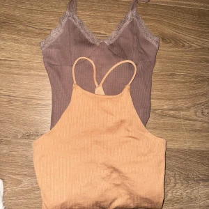 Två klänningar i beige och brun - Säljer två snygga klänningar. En ribbad beige med smala axelband och en brun klänning med spets och v-ringning 