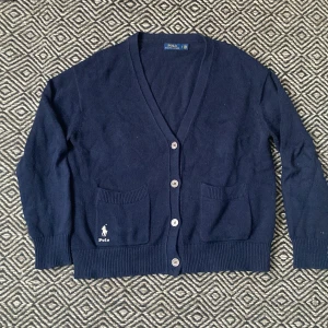 Cardigan/kofta från Polo Ralph Lauren - En mörblå cardigan/kofta från Polo Raulph Lauren i storlek M