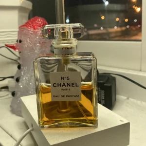 Chanel No. 5 Eau de Parfum - Halvfull. Elegant och tidlös Chanel No. 5 Eau de Parfum i en klassisk fyrkantig glasflaska med en stilren etikett. Parfymen har en gyllene färg och flaskan rymmer 50 ml. Perfekt för den som älskar ikoniska dofter.