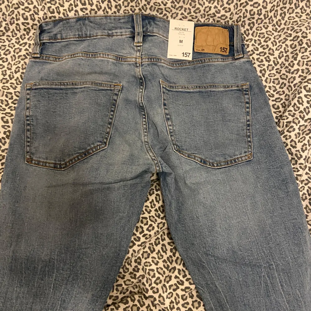 Snygga blå jeansbyxor med klassisk femficksdesign och raka ben. Byxorna har en knappgylf och är tillverkade i slitstarkt denimtyg. Perfekta för en avslappnad stil.. Farkut & Housut.