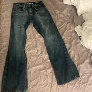 Mörkblå jeans från Blend Denim - Snygga mörkblå jeans från Blend Denim med en klassisk femficksdesign. De har en rak passform och är perfekta för en avslappnad stil. Jeansen har en diskret tvättad look och är tillverkade i slitstarkt denim.