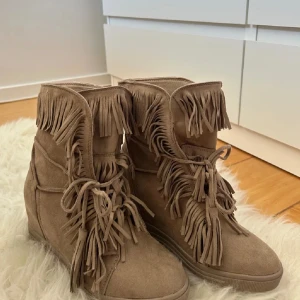 Fransskor - Snygga beige boots med fransar och snörning. Använda 1-2 gånger, några tecken på användning. Skorna har även en klack🥰