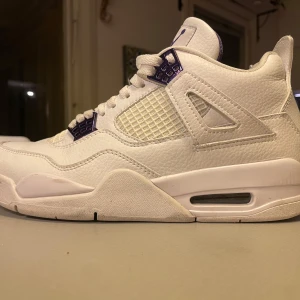 Purple metallics  - Säljer ett par vita Nike Air Jordans med lila detaljer. Skorna har klassisk snörning och en stilren design med meshpaneler för extra ventilation. Perfekta för sneaker-entusiaster!  Priset kan diskuteras. Använd 2-3 gånger 