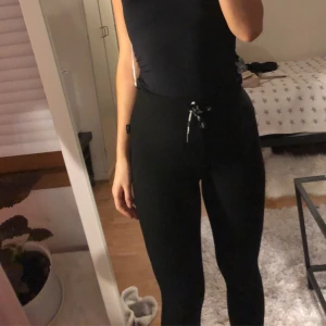 Svarta ribbade Stronger byxor - Bekväma tights från Stronger. Passar till träning, som underställ eller vardagsmys!