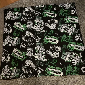 Svart sjal med Tokio hotel i bomull - Cool sjal med grönt och vitt Tokio Hotel-motiv. Perfekt för fans av bandet med ett unikt tryck som inkluderar bandets logga och bilder. En mysig och stilren accessoar för hemmet.
