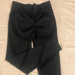 Svarta leggings med scrunch-detalj - Snygga svarta leggings med scrunch-detalj bak för en smickrande passform. Perfekta för både träning och vardag. Högmidjade och tillverkade i ett stretchigt material för bästa komfort.