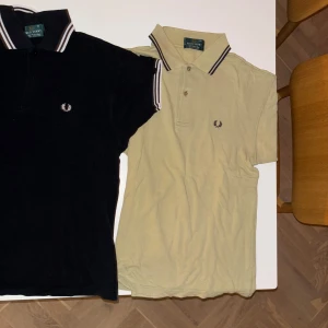 Svart och beige pikétröja från Fred Perry - Två klassiska pikétröjor från Fred Perry i svart och beige. Båda har korta ärmar och krage. Storlek xs men sitter bra på mig som har s/m. (Kan köpas separat 250 kr st)