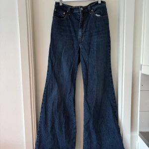 Levi's Ribcage Bell Jeans - Snygga Levi's Ribcage Bell jeans i en klassisk blå färg, sonoma train heter färgen. Dessa jeans har en hög midja och en utsvängd bootcut-stil som ger en retrokänsla. W29 L32.