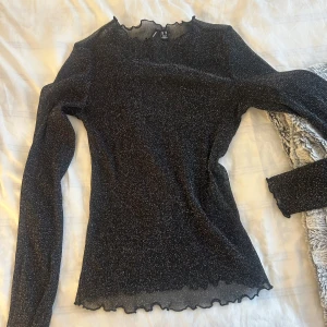 Svart glittrig topp från Vero Moda - Snygg svart glittrig topp från Vero Moda i storlek XS, men passar upp till M då den är väldigt stretchig.💖 inga defekter