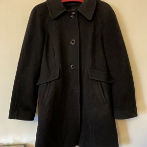 Svart kappa i ylle - Svart ylle kappe som har älskats och tagits hand om så är i gott skick. Köpt på beyond retro för ett år sedan. Finns att hämta i Sandborg, eller mötas upp på Södermalm. Går att få hemskickad men köpare står för frakt.