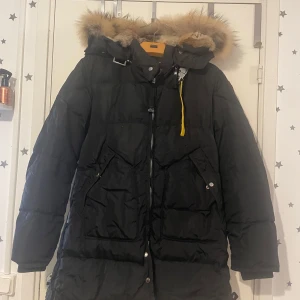 Svart dunjacka från Parajumpers - Säljer en svart dunjacka från Parajumpers med pälsfodrad huva. Jackan har dragkedja och knappar framtill samt flera praktiska fickor. Perfekt för kalla vinterdagar. Pris kan diskuteras.