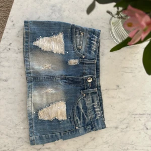Jeanskjol - FAST PRIS‼️‼️Trendig blå jeanskjol med slitningar och pärldetaljer. Super coola och unika detaljer. Midjemått 76cm