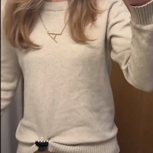 Beige stickad tröja - Säljer en stilren beige stickad tröja med rund halsringning. Tröjan har långa ärmar och ribbade detaljer vid hals, ärmslut och nederkant. Perfekt för kyligare dagar!