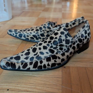 Leopardmönstrade loafers från Bianco - Snygga loafers med leopardmönster från Bianco. Skorna har en spetsig tå och är tillverkade i ett material som liknar päls. Perfekta för att ge en djärv touch till din outfit. Köpta för 1600kr säljer för 900kr. 