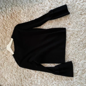 Svart långärmad tröja - Snygg svart långärmad tröja med vida ärmslut. 