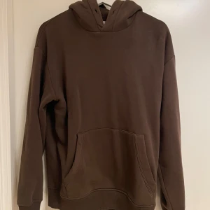 Brun hoodie från Zara - Säljer en stilren brun hoodie från Zara. Den har en klassisk design med en stor ficka framtill och en bekväm huva. Perfekt för en avslappnad look.