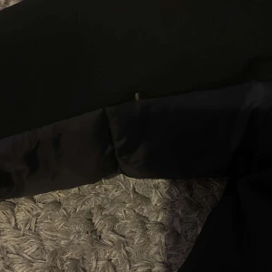 Sail racing pufferjacka - Säljer en svart pufferjacka med långärmad design. Jackan har en quiltad stil och är perfekt för kyligare väder. Den är tillverkad i syntetmaterial och har en klassisk passform.