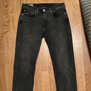 Svarta Levi's jeans - Säljer ett par svarta Levi's 514 jeans. De har en rak/ slim passform och klassisk design med fem fickor och knappgylf. Perfekta för en stilren look. Använd 2 gånger mer eller mindre nyskick. Färgen är gråaktig egentligen men jag satte svart. Nypris 1200