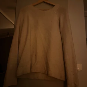 Beige stickad tröja - Mysig beige stickad tröja med rund hals och långa ärmar. Perfekt för kyliga dagar och enkel att matcha med olika outfits. Lite nopprig men inga större defekter😇