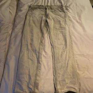 Beige jeansbyxor - Snygga beige jeansbyxor med en klassisk design. De har en rak passform och är perfekta för en avslappnad stil. Byxorna har fickor både fram och bak samt hällor för bälte.