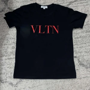 Valentino t shirt - Snygg svart t-shirt från Valentino med röd VLTN-logga på framsidan. Perfekt för en stilren look. Kortärmad och i mjukt material.