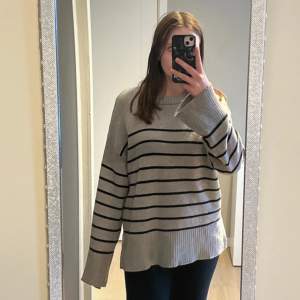 Fin grå stickad tröja med svarta ränder