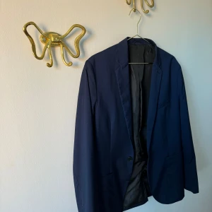 Mörkblå kavaj - Snygg mörkblå kavaj med klassisk passform. Perfekt för både formella och avslappnade tillfällen. Kavajen har en enkel knäppning och är helfodrad för extra komfort. Från herravdelning men så snygg att bära som tjej.