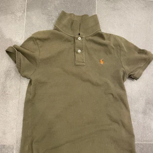 Mörkgrön Ralph lauren Piké - Säljer denna stilrena piké ifrån Ralph lauren. Tröjan har inga defekter alls och är i storleken 14-16(barnstorlek) som motsvarar ungefär xs i vuxen storlek. Vid smidig affär så fraktar jag samma dag! Hör av er vid funderingar!💫