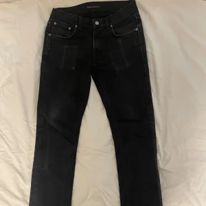 Svarta jeans från Nudie Jeans - Svarta jeans från Nudie. Snygga utmarkeringar både på framfickorna och bakfickorna. Bra skick, men man ser att dom är använda. I min åsikt tycker jag dock det bara gör dom snyggare. 