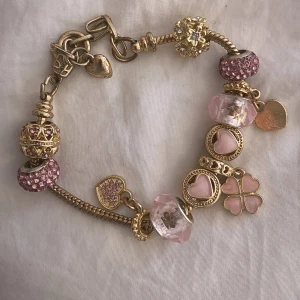 Guldigt armband med rosa berlocker  - Ett såååå vackert armband som ser nästan exakt ut som Pandora armbanden i superfint skick💞💞Det är även justerbart💞