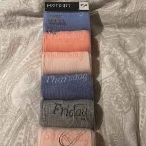 Färgglada veckodagsstrumpor från Esmara - Sju par strumpor från Esmara i olika färger, en för varje veckodag. Tillverkade av 81% bomull, 18% polyamid och 1% elastan för komfort och hållbarhet. Perfekta för att ge lite färg till vardagen. förpackningen har lyckats öppnas under flytt men är inte använda eller tagna ur förpackningen!🥰