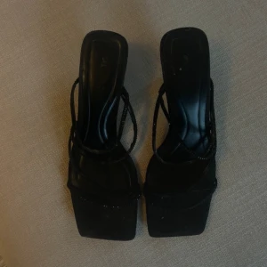 Svarta klackskor med remmar - Eleganta svarta klackskor med smala glittriga remmar och fyrkantig tå.