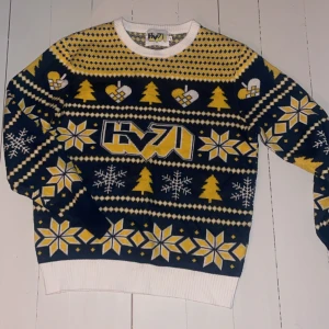 Mönstrad tröja i blått och gult - En snygg hv stickad jul tröja. Tröjan har ett unikt mönster med hjärtan, snöflingor och granar. Perfekt för vintern och julen! Den har långa ärmar och en bekväm passform. Använd fåtal gånger så mycket bra skick storlek M men mindre i storlek 