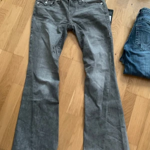 Grå jeans med låg midja True Religion - Snygga grå jeans från True Religion med låg midja och flare-stil. Endast provade, helt nyskick.