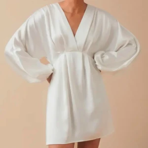 Vit kortklänning med v-ringning - Elegant vit kortklänning med v-ringning och långa, lösa ärmar. Perfekt för en stilren look med en touch av enkelhet. Använd bara 1 gång