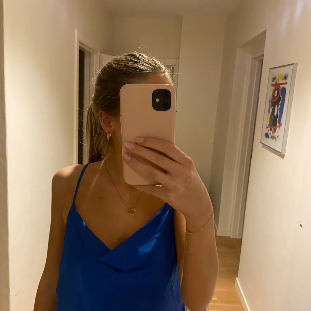 Snygg blå ärmlös topp med smala axelband och djup urringning. Perfekt för varma dagar eller en kväll ute. Enkel och stilren design som passar till många olika outfits.. Yläosat.
