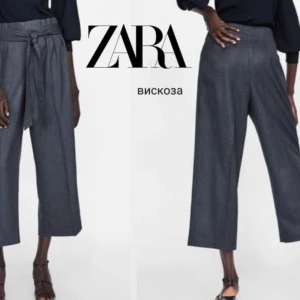 Grå vida byxor från Zara - Snygga grå vida byxor från Zara i viskosmaterial. Byxorna har en hög midja och ett knytband i midjan för extra stil. Perfekta för en chic och avslappnad look. Oanvända strl S