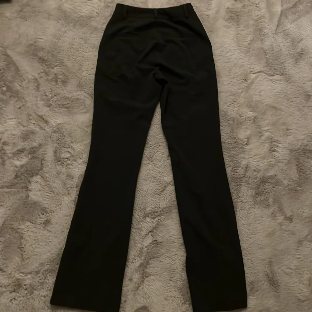 Snygga mörkgrå kostymbyxor från BikBok i en klassisk design. Byxorna har en hög midja och en rak passform som ger en stilren look. Perfekta för en chic och elegant stil. . Farkut & Housut.